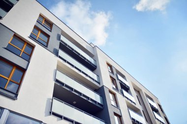 Mavi gökyüzü olan güneşli bir günde modern apartman binaları. Modern bir apartmanın cephesi