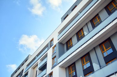 Mavi gökyüzü olan güneşli bir günde modern apartman binaları. Modern bir apartmanın cephesi