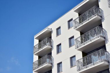 Mavi gökyüzü olan güneşli bir günde modern apartman binaları. Modern bir apartmanın cephesi