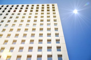 Modern ofis binası detayı. Güneş ışığı ile modernist brutalist tarzı bina yüzeyinin cephesinde geometrik açısal beton pencerelerperspektif görünümü.