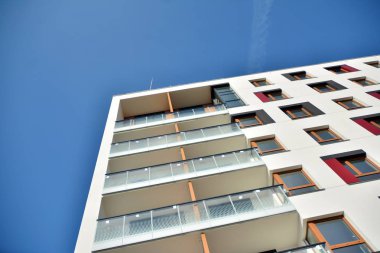 Mavi gökyüzü olan güneşli bir günde modern apartman binaları. Modern bir apartmanın cephesi