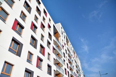 Mavi gökyüzü olan güneşli bir günde modern apartman binaları. Modern bir apartmanın cephesi