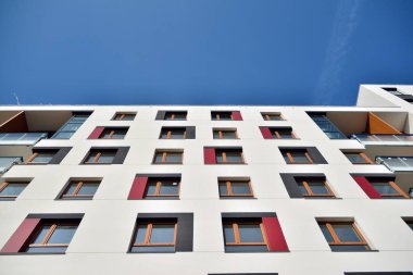 Mavi gökyüzü olan güneşli bir günde modern apartman binaları. Modern bir apartmanın cephesi
