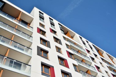 Mavi gökyüzü olan güneşli bir günde modern apartman binaları. Modern bir apartmanın cephesi