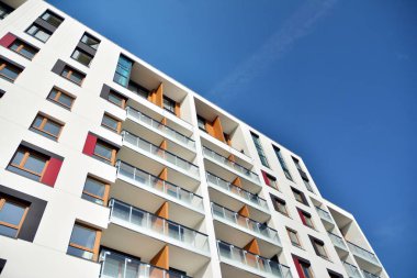 Mavi gökyüzü olan güneşli bir günde modern apartman binaları. Modern bir apartmanın cephesi