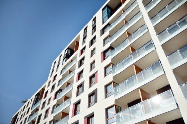 Mavi gökyüzü olan güneşli bir günde modern apartman binaları. Modern bir apartmanın cephesi