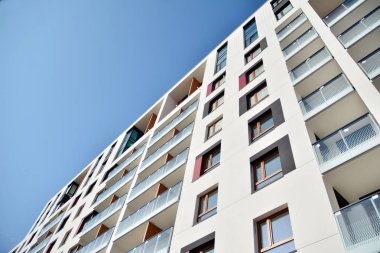 Mavi gökyüzü olan güneşli bir günde modern apartman binaları. Modern bir apartmanın cephesi