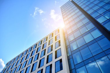 Cam aynalı ofis binasının ön dokusu. Ön cephenin bir parçası. Günbatımında akşam ışığında mercek filtre efektiyle modern gökdelenlerin en alt görüntüsü.