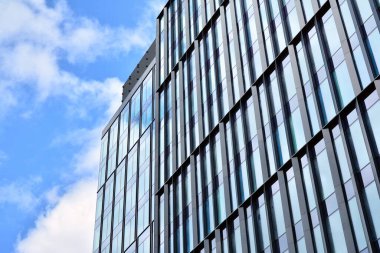 Cam aynalı ofis binasının ön dokusu. Ön cephenin bir parçası. Ofis binasının modern mimarisi.