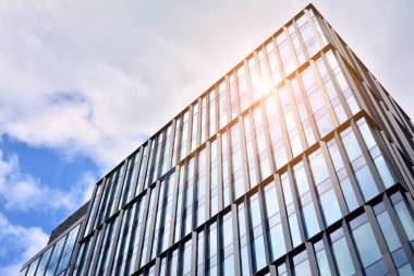 Cam aynalı ofis binasının ön dokusu. Ön cephenin bir parçası. Günbatımında akşam ışığında mercek filtre efektiyle modern gökdelenlerin en alt görüntüsü.