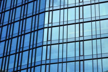 Cam aynalı ofis binasının ön dokusu. Ön cephenin bir parçası. Ofis binasının modern mimarisi.