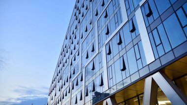 Cam aynalı ofis binasının ön dokusu. Ön cephenin bir parçası. Ofis binasının modern mimarisi.