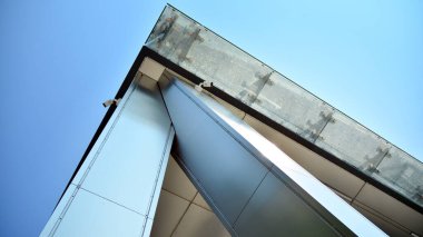 Metal ve cam duvar malzemelerinin karışımı. Sütunlarda çelik cephe. Soyut modern mimari. Yüksek teknoloji minimalist ofis binası. Çağdaş iş mimarisi soyut parça.