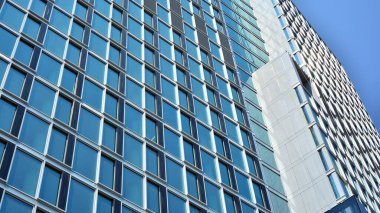Cam aynalı ofis binasının ön dokusu. Ön cephenin bir parçası. Ofis binasının modern mimarisi.