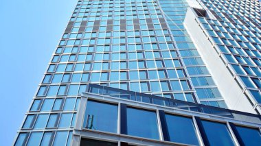 Cam aynalı ofis binasının ön dokusu. Ön cephenin bir parçası. Ofis binasının modern mimarisi.