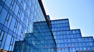 Cam aynalı ofis binasının ön dokusu. Ön cephenin bir parçası. Ofis binasının modern mimarisi.