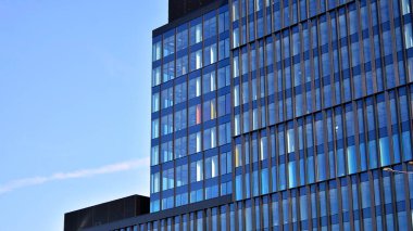 Cam aynalı ofis binasının ön dokusu. Ön cephenin bir parçası. Ofis binasının modern mimarisi.