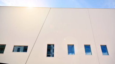 Modern cam ve beton binaya bakmanın soyut görüntüsü. Ofis binasının mimari dış ayrıntıları. Endüstriyel sanat ve detay. Güneş ışığıyla cam yüzey.