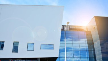 Modern cam ve beton binaya bakmanın soyut görüntüsü. Ofis binasının mimari dış ayrıntıları. Endüstriyel sanat ve detay. Güneş ışığıyla cam yüzey.