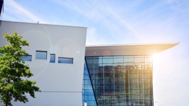 Modern cam ve beton binaya bakmanın soyut görüntüsü. Ofis binasının mimari dış ayrıntıları. Endüstriyel sanat ve detay. Güneş ışığıyla cam yüzey.