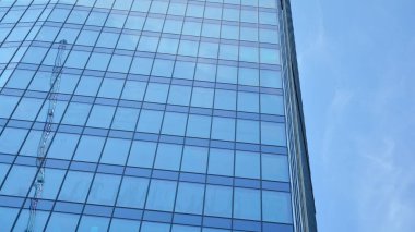 Gökdelenlerin cam siluetinin alt görüntüsü. İş binası. Cam cepheli bir gökdelen. İş bölgesinde modern bir bina. Ekonomi, finans, gelecek kavramları.   