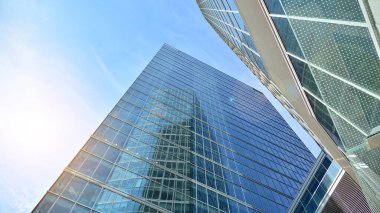Gökdelenlerin cam siluetinin alt görüntüsü. İş binası. Cam cepheli bir gökdelen. İş bölgesinde modern bir bina. Ekonomi, finans, gelecek kavramları.   