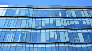 Modern ofis binasının cam perde duvarı. Gökyüzü arka planında modern ofis binası.