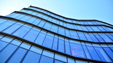 Modern ofis binasının cam perde duvarı. Gökyüzü arka planında modern ofis binası.