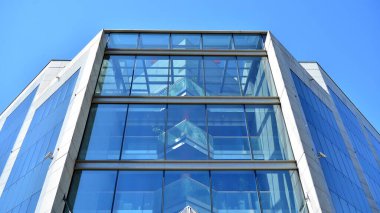Modern ofis binasının cam perde duvarı. Gökyüzü arka planında modern ofis binası.