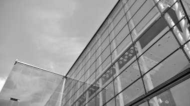 Çelik ve camdan yapılmış, mavi gökyüzü olan modern ofis duvarı. Siyah ve beyaz.