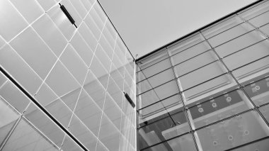 Çelik ve camdan yapılmış, mavi gökyüzü olan modern ofis duvarı. Siyah ve beyaz.