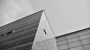 Çelik ve camdan yapılmış, mavi gökyüzü olan modern ofis duvarı. Siyah ve beyaz.