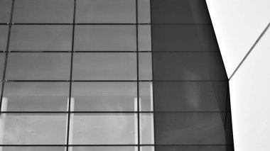 Çelik ve camdan yapılmış, mavi gökyüzü olan modern ofis duvarı. Siyah ve beyaz.