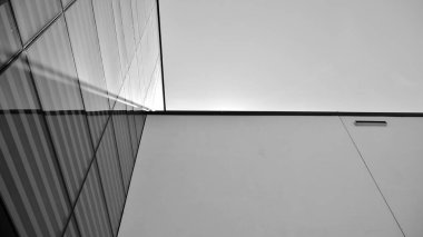 Çelik ve camdan yapılmış, mavi gökyüzü olan modern ofis duvarı. Siyah ve beyaz.