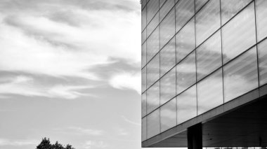 Çelik ve camdan yapılmış, mavi gökyüzü olan modern ofis duvarı. Siyah ve beyaz.