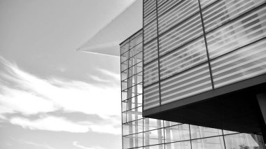 Çelik ve camdan yapılmış, mavi gökyüzü olan modern ofis duvarı. Siyah ve beyaz.