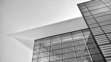 Çelik ve camdan yapılmış, mavi gökyüzü olan modern ofis duvarı. Siyah ve beyaz.