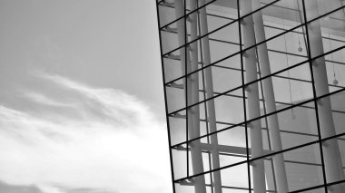 Çelik ve camdan yapılmış, mavi gökyüzü olan modern ofis duvarı. Siyah ve beyaz.