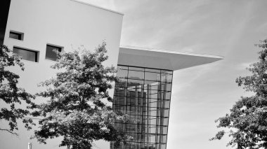 Çelik ve camdan yapılmış, mavi gökyüzü olan modern ofis duvarı. Siyah ve beyaz.