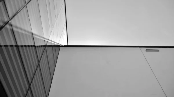 青い空と鋼とガラスで作られた近代的なオフィスビルの壁 黒と白 — ストック写真