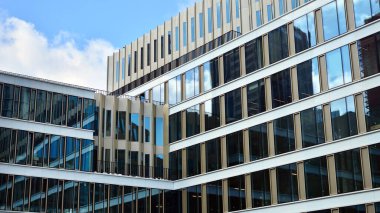 Ofis binası, mavi cam duvar yansıtma detayı. Modern ofis binası ve temiz gökyüzü arkaplanı. 