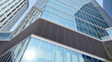 Gökdelenlerin cam siluetinin alt görüntüsü. İş binası. Cam cepheli bir gökdelen. İş bölgesinde modern bir bina. Ekonomi, finans, gelecek kavramları.   