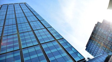 Gökdelenlerin cam siluetinin alt görüntüsü. İş binası. Cam cepheli bir gökdelen. İş bölgesinde modern bir bina. Ekonomi, finans, gelecek kavramları.   
