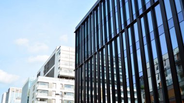 Gökdelenlerin cam siluetinin alt görüntüsü. İş binası. Cam cepheli bir gökdelen. İş bölgesinde modern bir bina. Ekonomi, finans, gelecek kavramları.   