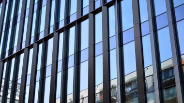 Gökdelenlerin cam siluetinin alt görüntüsü. İş binası. Cam cepheli bir gökdelen. İş bölgesinde modern bir bina. Ekonomi, finans, gelecek kavramları.   