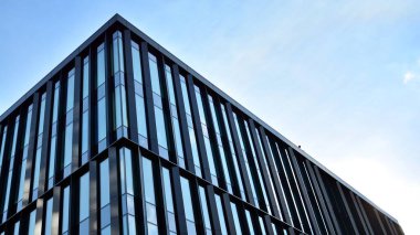 Gökdelenlerin cam siluetinin alt görüntüsü. İş binası. Cam cepheli bir gökdelen. İş bölgesinde modern bir bina. Ekonomi, finans, gelecek kavramları.   