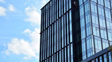 Gökdelenlerin cam siluetinin alt görüntüsü. İş binası. Cam cepheli bir gökdelen. İş bölgesinde modern bir bina. Ekonomi, finans, gelecek kavramları.   