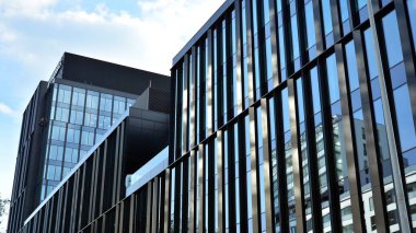 Gökdelenlerin cam siluetinin alt görüntüsü. İş binası. Cam cepheli bir gökdelen. İş bölgesinde modern bir bina. Ekonomi, finans, gelecek kavramları.   