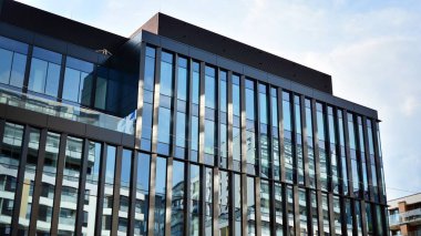 Gökdelenlerin cam siluetinin alt görüntüsü. İş binası. Cam cepheli bir gökdelen. İş bölgesinde modern bir bina. Ekonomi, finans, gelecek kavramları.   