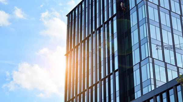 Office building, details of blue glass wall and sun reflections.